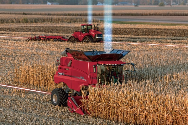 Red Tractor and Combine harvesting wheat field.