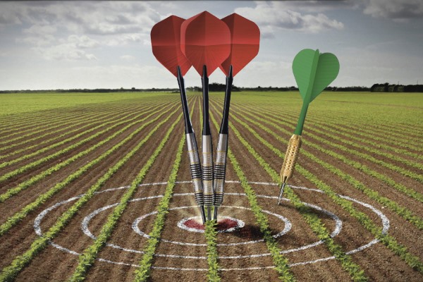 Four 20ft darts hitting a bulls-eye painted onto an agriculture field.